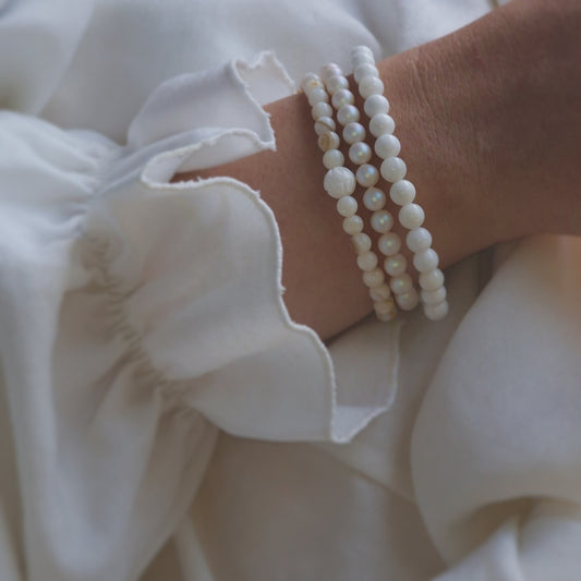 alt="White gemstone wrap bracelet styled with pastel summer outfit