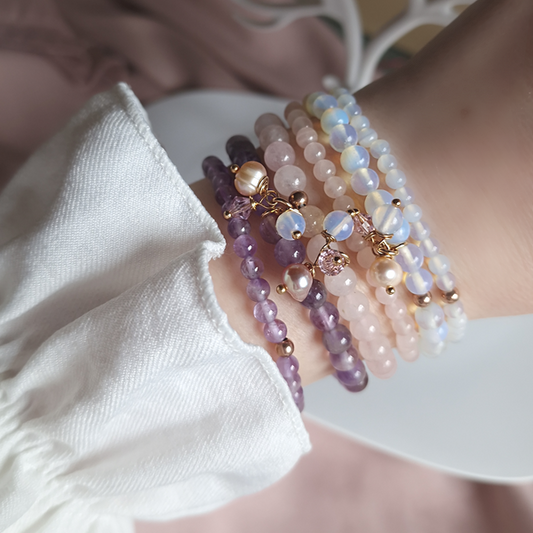 Set of handmade crystal bracelets featuring rose quartz and amethyst stones