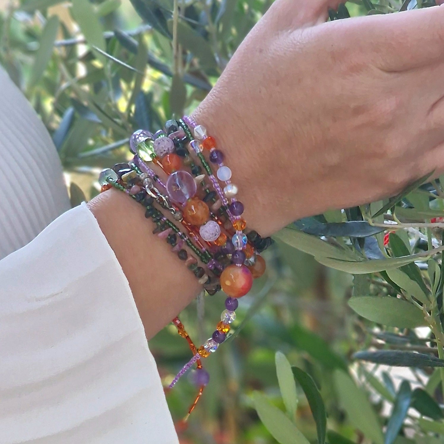 A 188 cm multi-stone wrap necklace draped around a woman’s neck, showcasing agate, amethyst, tourmaline, rose quartz, jadeite, peridot, moonstone, opalite and sunstone beads